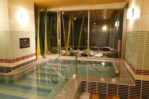 a swimming pool with a shower in a building at Dormy Inn Premium Namba Natural Hot Spring in Osaka