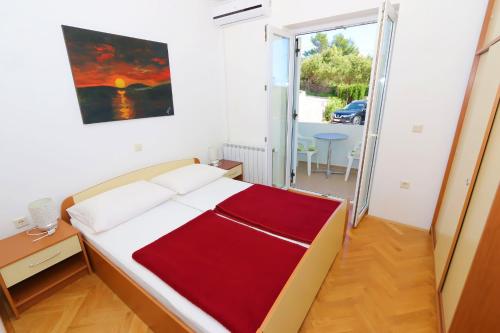 a bedroom with a bed with a red blanket at Apartments Delminium in Lun