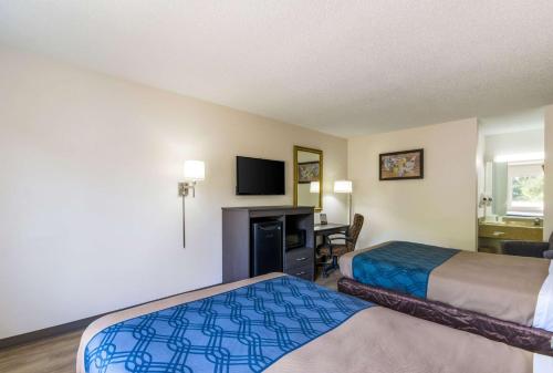 a hotel room with two beds and a flat screen tv at Econo Lodge Little Creek in Norfolk
