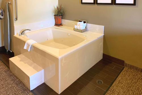 a large white bath tub in a bathroom at Comfort Suites Texas Ave in College Station