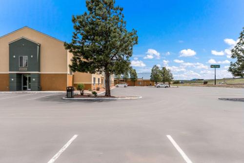 a parking lot in front of a building with a tree at Quality Inn Williams Near Grand Canyon in Williams