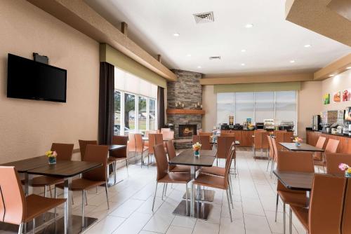 a restaurant with tables and chairs and a fireplace at Quality Inn Williams Near Grand Canyon in Williams
