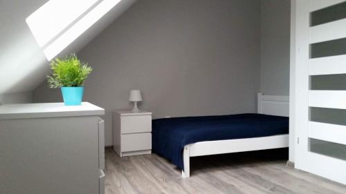 1 dormitorio con 1 cama con manta azul en ZMIANA KLIMATU en Karwia