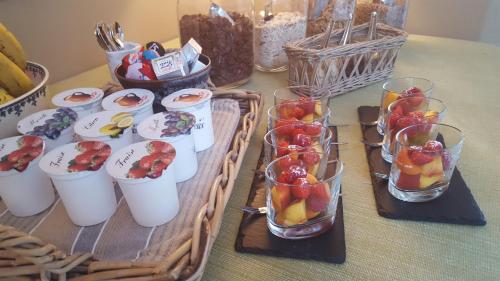 Una mesa con una bandeja de fruta en vasos de cristal. en Chateauret, en Espagnac