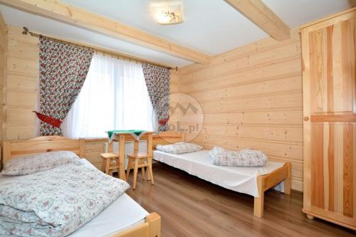 a bedroom with two beds and a table in it at Willa Swajnos in Zakopane