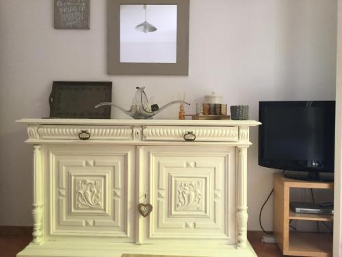 - une cheminée blanche dans le salon avec une télévision dans l'établissement Les Milles Plantes, à Saint-Aygulf