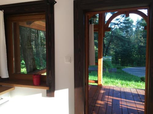 an open door with a view of a yard at 3pokoje - Domek lub Pokój pod lasem na odludziu, jacuzzi, sauna, kominek, Roztocze in Susiec