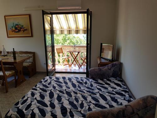 a bedroom with a bed and a door to a deck at Vila Kajče in Omišalj