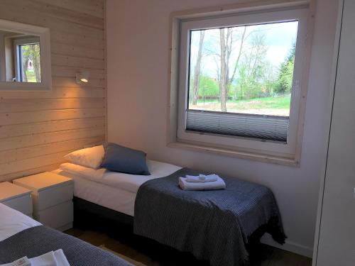 a small bedroom with a bed and a window at 3pokoje - Domek lub Pokój pod lasem na odludziu, jacuzzi, sauna, kominek, Roztocze in Susiec