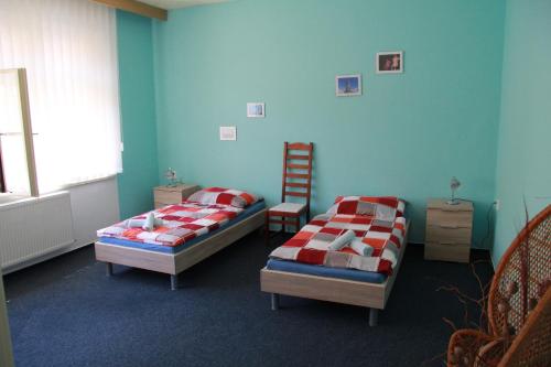 ein Zimmer mit 2 Betten und einem Stuhl darin in der Unterkunft Apartmán Brašov, Týn nad Vltavou in Týn nad Vltavou