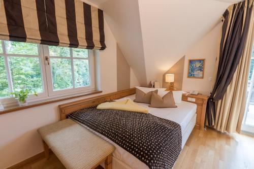 a bedroom with a bed and two windows at Romantik Hotel Namenlos in Ahrenshoop