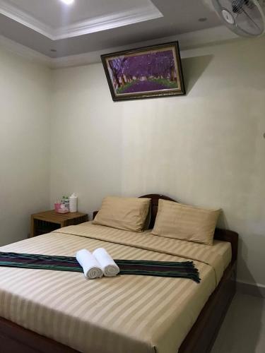 a bedroom with a bed with two towels on it at Manel Guesthouse and Restaurant in Sen Monorom