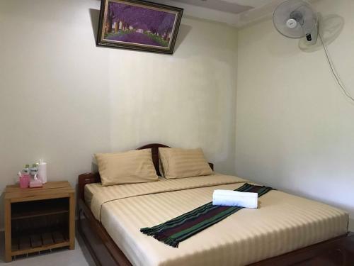a bedroom with a bed with a table and a picture on the wall at Manel Guesthouse and Restaurant in Sen Monorom