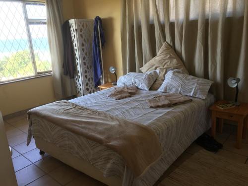 Un dormitorio con una cama con dos toallas encima. en Go Slow, en Port Shepstone
