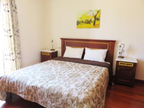 a bedroom with a bed and two nightstands at Traditional apartment with view in Douliana Vamos in Douliana