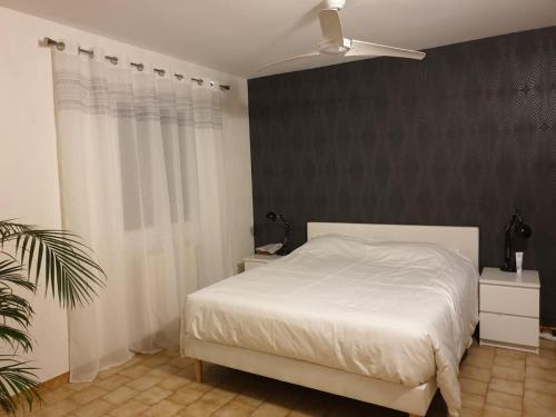 - une chambre avec un lit blanc et un mur noir dans l'établissement Villa privative avec grande piscine au coeur de la Drôme, à Allex