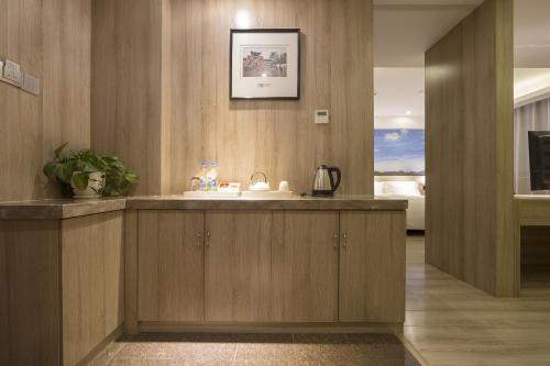 a kitchen with wooden cabinets and a sink at Atour Hotel (Taiyuan Zonggai Shifanqu) in Taiyuan