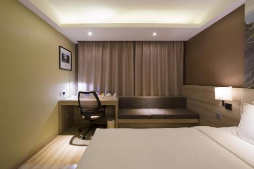 a hotel room with a bed and a desk with a chair at Atour Hotel (Taiyuan Zonggai Shifanqu) in Taiyuan