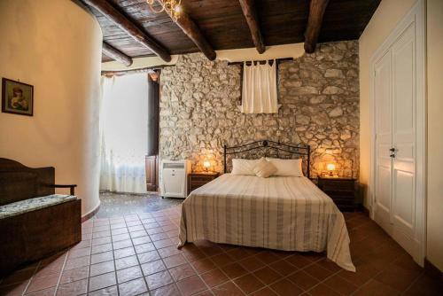 una camera con letto e parete in pietra di PietrAnticA a Trentinara