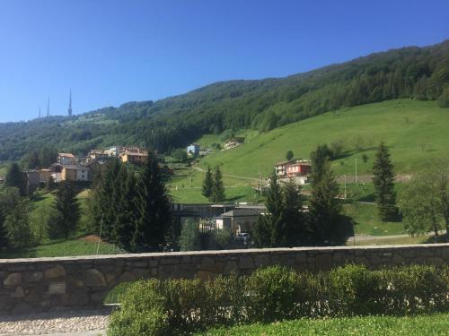 a village on a hill with houses and trees at Residence La Canonica in Costa Valle Imagna