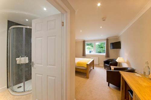 a bathroom with a large window and a large bed at Falls of Lora Hotel in Oban