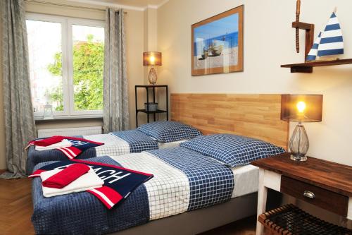 sypialnia z 2 łóżkami, biurkiem i oknem w obiekcie Blue Grey Atelier w mieście Sopot