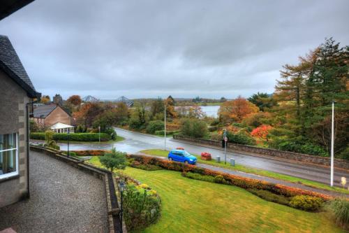 a blue car parked on a street in a town at Falls of Lora Hotel in Oban