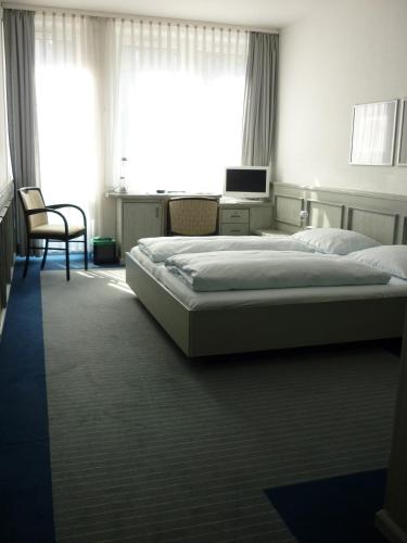 a bedroom with two beds and a desk with a computer at Avenue Hotel in Nürnberg