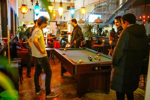 a group of men playing pool in a bar at Chengdu Flipflop Hostel Poshpacker (Chunxi Road Metro Station) in Chengdu