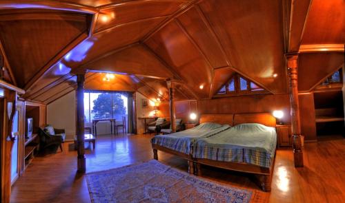 um quarto com uma cama num quarto grande em Hotel Clouds End Villa Cottages em Dharamshala