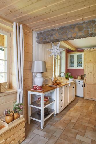 a kitchen with wooden walls and a table with a lamp at Gorce Oasis in Szlembark