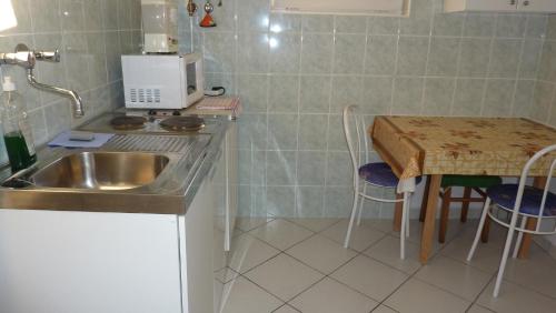 una cucina con un lavello e un tavolo con sedie di Bridgehaus a Balatonfüred