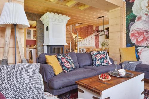 a living room with a purple couch and a fireplace at Gorce Oasis in Szlembark