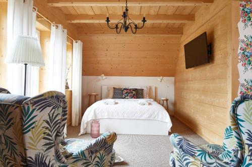 a bedroom with a bed and two chairs at Gorce Oasis in Szlembark