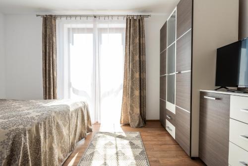 a bedroom with a bed and a large window at La Tusa Dusa in Ocolişu Mic