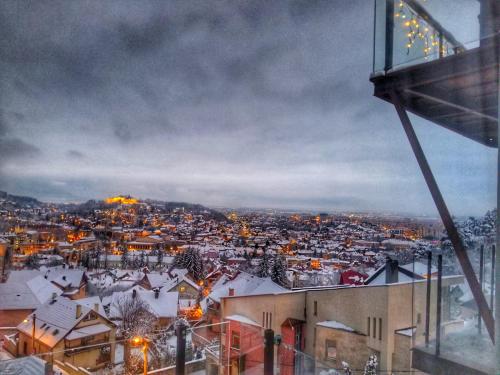 a view of a city at night with snow at 5 Star Residence in Braşov