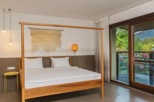a bedroom with a canopy bed and a window at Faros Hotel Bodrum - Special Category in Golturkbuku
