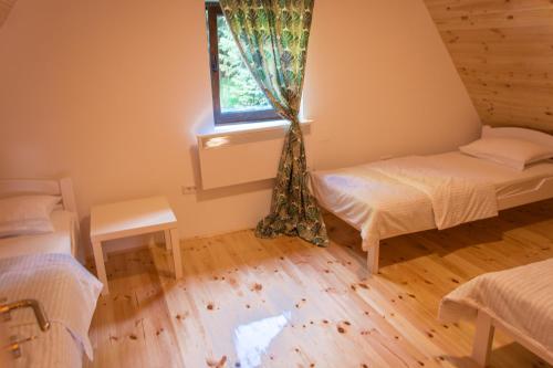 a room with two beds and a window at Wood Inn in Žabljak
