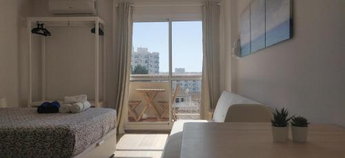 a bedroom with a bed and a large window at Sunny Suites Jupiter Apartments in Benalmádena