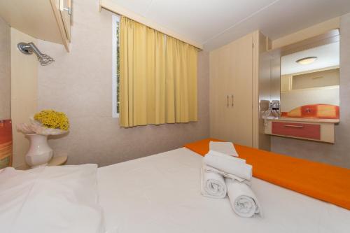 a bedroom with a bed with towels on it at Diana & Josip Mobile Homes in Biograd na Moru