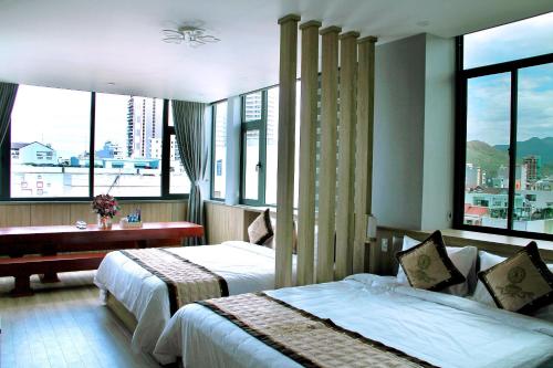 a hotel room with two beds and a window at RUBY LUXURY HOTEL in Quy Nhon