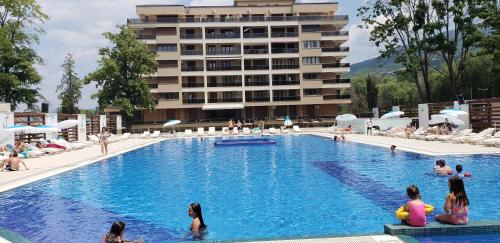 a large swimming pool with people in a hotel at Park Beach Apartments Sofi & Kiki in Ohrid