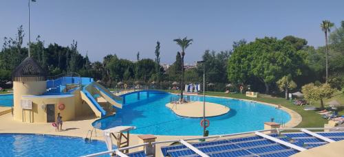 a large swimming pool with a slide at a resort at Sunny Suites Jupiter Apartments in Benalmádena