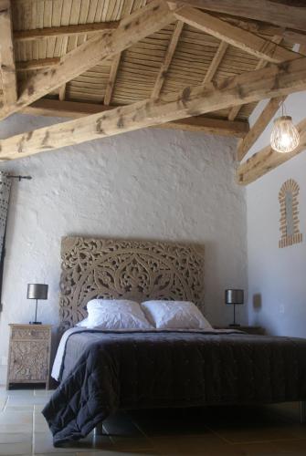 a bedroom with a large bed with a wooden headboard at VILLA PIETRA in Le Boupère