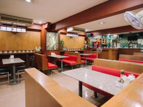 a restaurant with red chairs and tables in a room at Rendezvous Oldtown Chiangmai in Chiang Mai