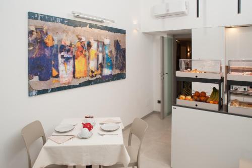 una sala da pranzo con tavolo e un dipinto sul muro di Wellness Home Rome a Roma