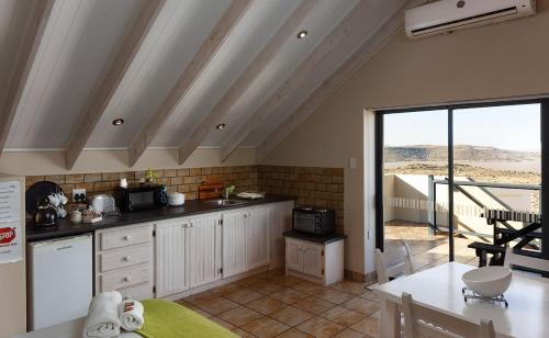 Una cocina con gabinetes blancos y encimera. en ADamsview, en Gariepdam