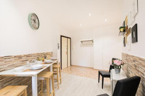 Un comedor con una mesa y sillas y un reloj. en Stars Luxury Apartments 1, en Roma