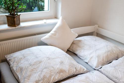 a bed with two pillows sitting next to a window at Casa Marina in Kulmbach