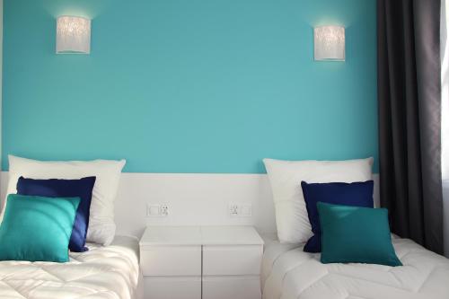 sala de estar con 2 sofás blancos y paredes azules en M&K Apartamenty-Amber, en Gdansk